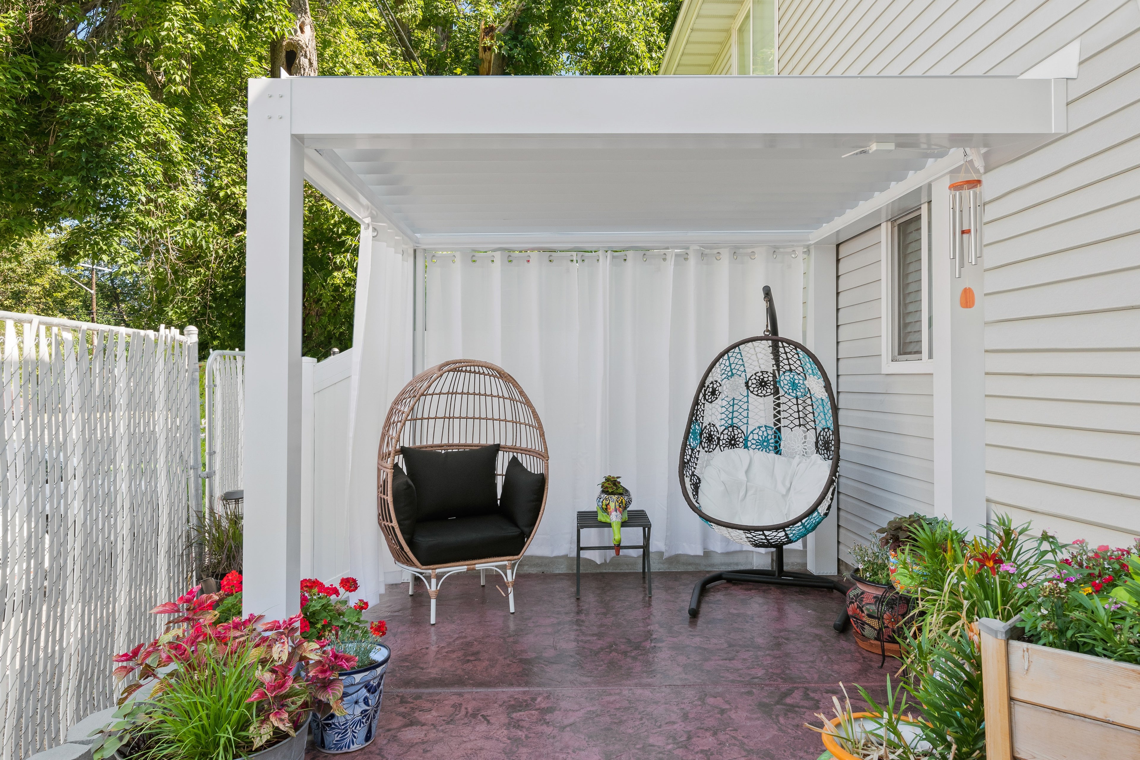 White Sundance All Season louvered pergola attached to the house over a small backyard patio